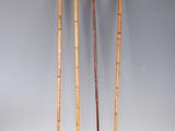 three bamboo walking canes are standing next to each other on a white surface