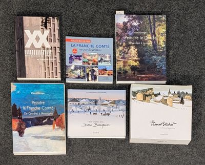 Plusieurs livres sont disposés en rangée sur une table.