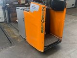 une petite machine orange garée dans un garage