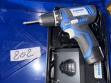 une perceuse sans fil dans une boîte bleue avec un chargeur