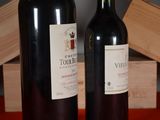 two bottles of wine sitting next to each other on a table