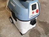 a blue and white vacuum sitting in a garage