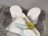 three salt and pepper shakers and a martini glass on the table