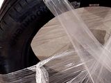 a tire wrapped in plastic and sitting on the ground