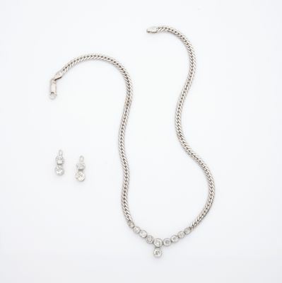 une photo d'un ensemble composé d'un collier et de boucles d'oreilles, posé sur un fond blanc