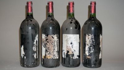 quatre bouteilles de vin sont alignées sur une table