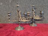 a silver candelab that is on a red cloth