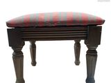 un petit banc sur lequel est posé un coussin rouge et bleu