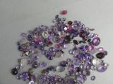 a pile of purple and white glass beads on a table