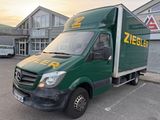 a green delivery truck parked in front of a building