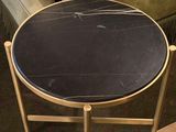 a small table with a black marble top on it