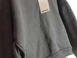 a close up of a black hoodie with a tag on it