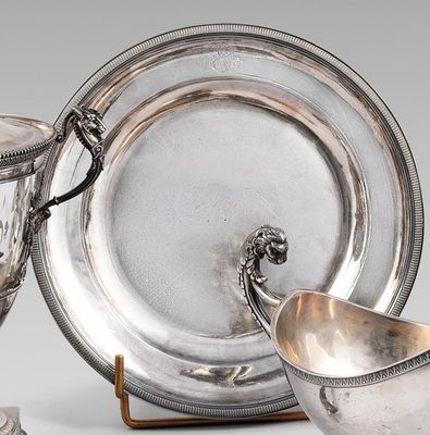 un plateau en argent sur lequel sont posés une tasse et une soucoupe en argent, le tout sur un socle