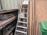 a ladder leaning up against a wall next to a pile of wood