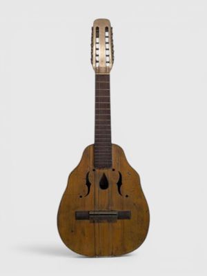 une vieille guitare en bois posée sur une surface blanche