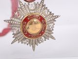 a red and gold medal hanging from a red ribbon