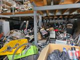 a pile of junk in a garage with a lot of tools