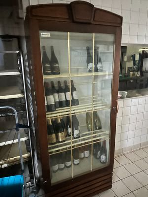 des bouteilles de vin se trouvent dans une vitrine en verre dans une cuisine