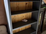 Quelqu'un est en train de peindre une bibliothèque dans un salon dont les murs sont recouverts de boiseries.