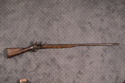 un fusil posé par terre à côté d'un pistolet jouet