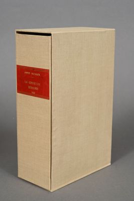 an old book sitting on top of a table next to a gray wall