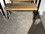 three wooden benches in front of a table with a laptop on it