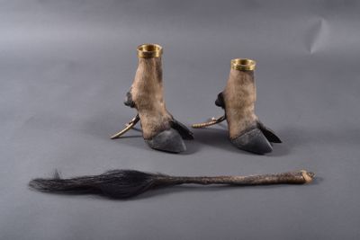 deux paires de chaussures et un balai posés sur une surface grise