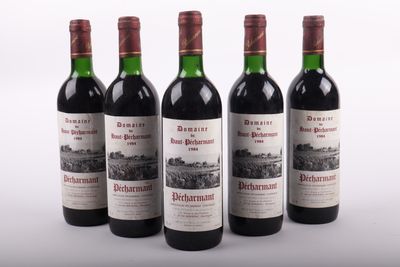 quatre bouteilles de vin rouge sont alignées sur une surface blanche