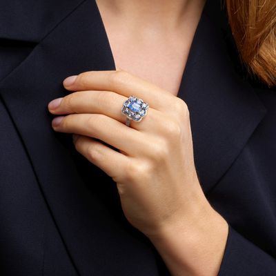 the woman is wearing a ring that has a blue stone in it