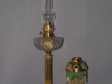 une lampe en or et un vase en verre posés sur une table