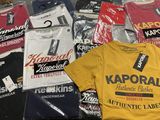 un grand nombre de t-shirts posés sur une table