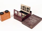 une petite boîte en bois contenant un livre et une petite boîte dans laquelle se trouve une image