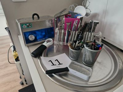 a silver tray with pens, pencils, and other office supplies on it