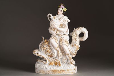 a figurine of a woman sitting on a dragon