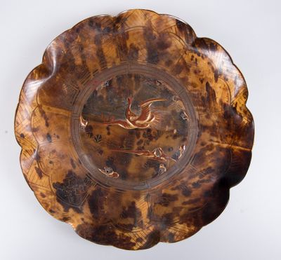 une assiette marron ornée d'un oiseau sur un fond blanc