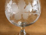 a glass with a leaf design on it on a table