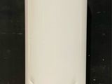 un chauffe-eau blanc posé sur un sol carrelé