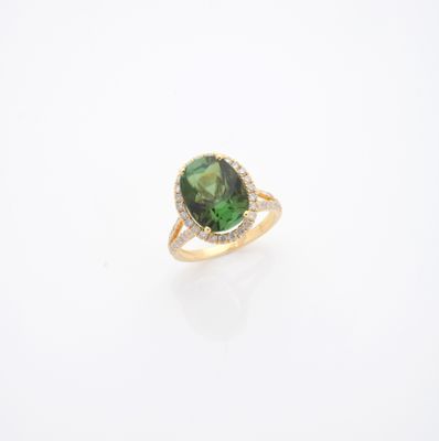 un gros plan sur une bague en tourmaline verte et diamants