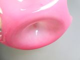 a person holding a pink cup with a toothbrush in it