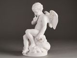 a statue of an angel sitting on top of a rock