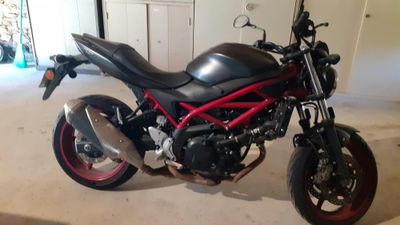 une moto noire et rouge garée dans un garage