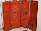 un paravent en bois rouge orné d'une peinture