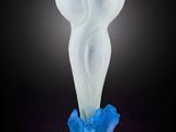 un vase blanc et bleu posé sur une surface noire