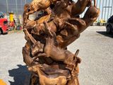 wooden sculpture of a group of animals on top of a pile of wood