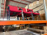 de nombreuses chaises rouges posées sur une étagère dans un entrepôt