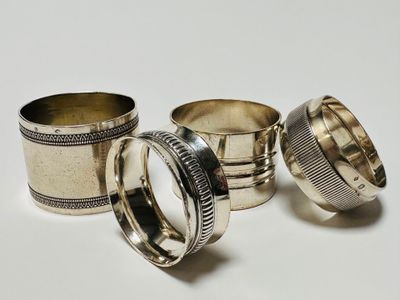 three silver napkins and two silver napkins on a white surface