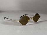 a pair of gold sunglasses with brown lenses on a white surface