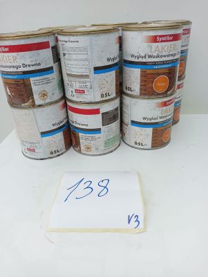 several cans of paint sitting on top of a table next to a sign