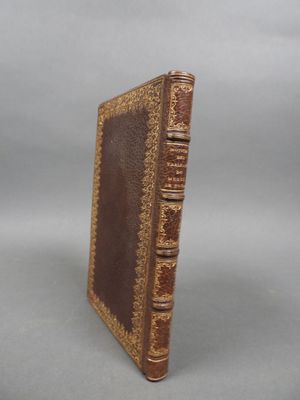 an old book sitting on top of a white table next to a gray background