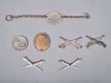 an image of a collection of silver and gold jewelry including a watch, a bracelet, a coin, and a keychain